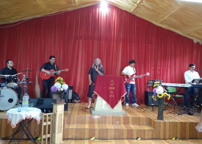Gladis Silva leads singing at the united worship service of the Iglesia Evangélica Menonita de Chile (IEMCH).