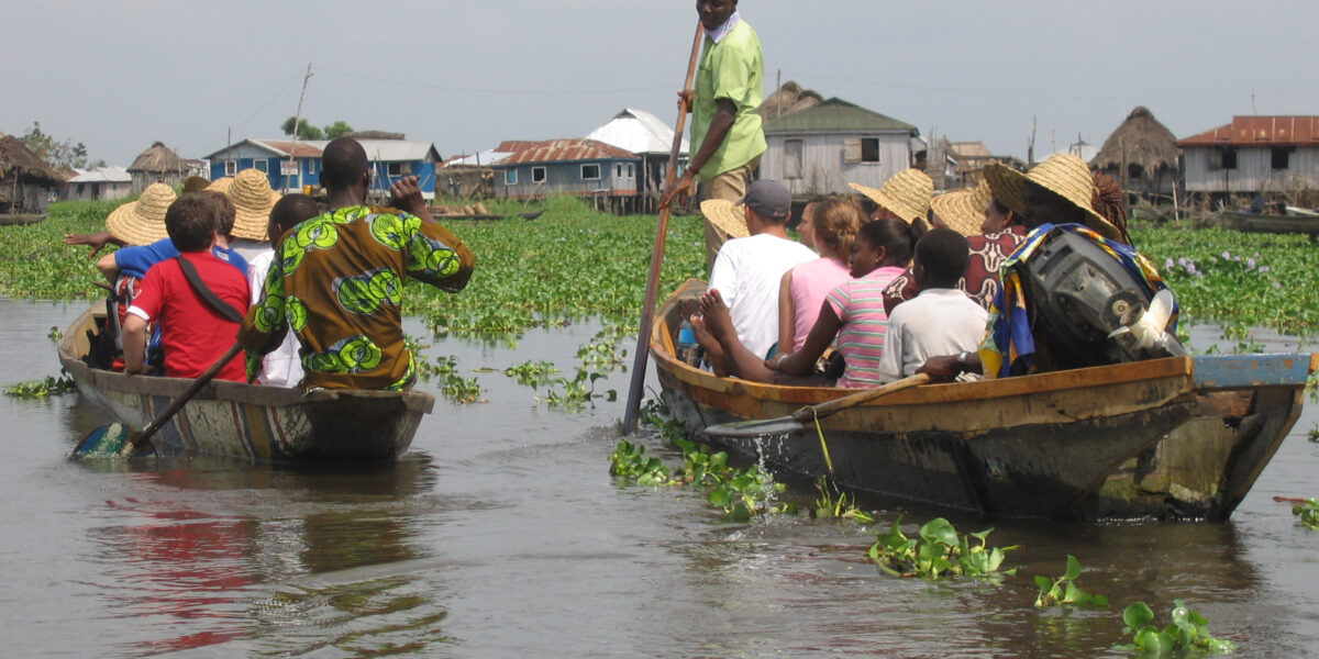 Inhabitants of Ganvié introduce a North American delegation to their village built on stilts over Lac Nokoué
