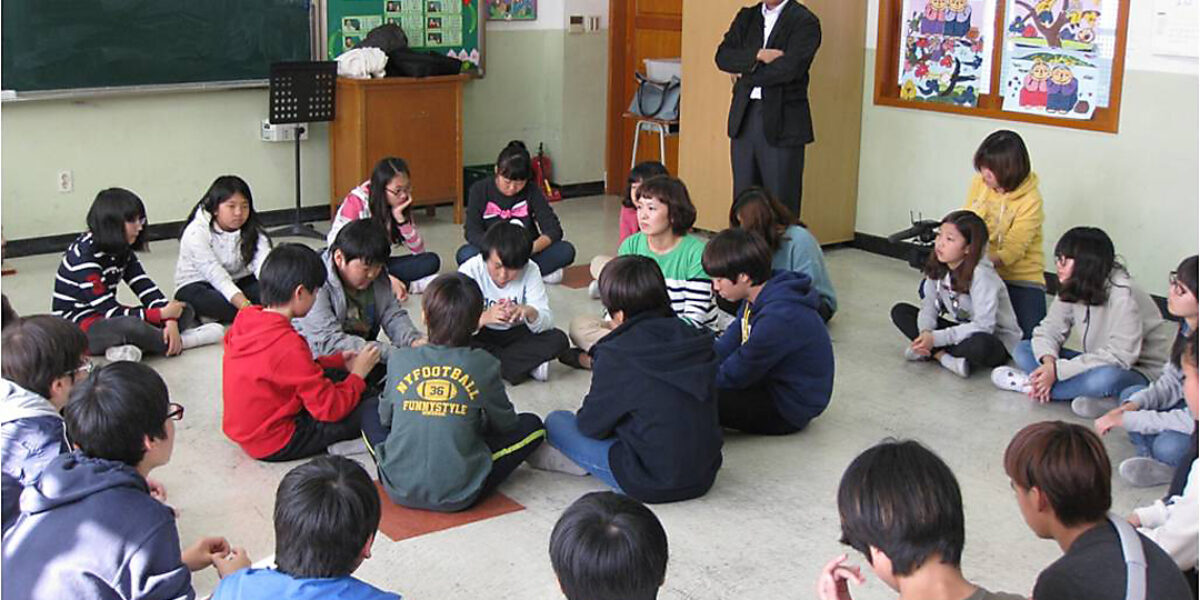 Jae Young Lee leads a restorative discipline class at an elementary school in Seoul. Students directly involved in bullying sit in the middle circle. Other classmates sit in the outside circle. Photo by KOPI staff. Download full-resolution image.