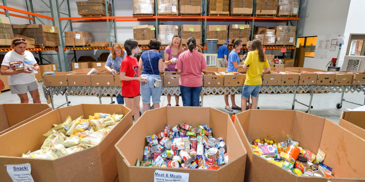 Youth volunteers fill boxes of food at St. Mary’s Food Bank in Phoenix as part of their servant project during Mennonite Church USA Convention. Download full-resolution image.