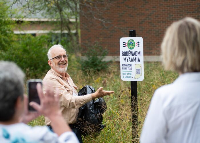 ​Dr. Luke Gascho unveils one of the four trail signs that were installed on the Anabaptist Mennonite Biblical Seminary campus on Sept. 29. Photographer: David Fast.