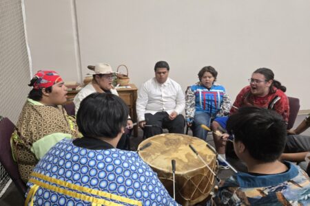 Dewy Bill, third from left, leads the Mending Wings singers and drummers. Photographer: Sarah Augustine.
