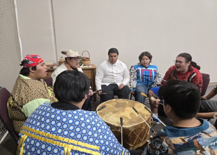 Dewy Bill, third from left, leads the Mending Wings singers and drummers. Photographer: Sarah Augustine.