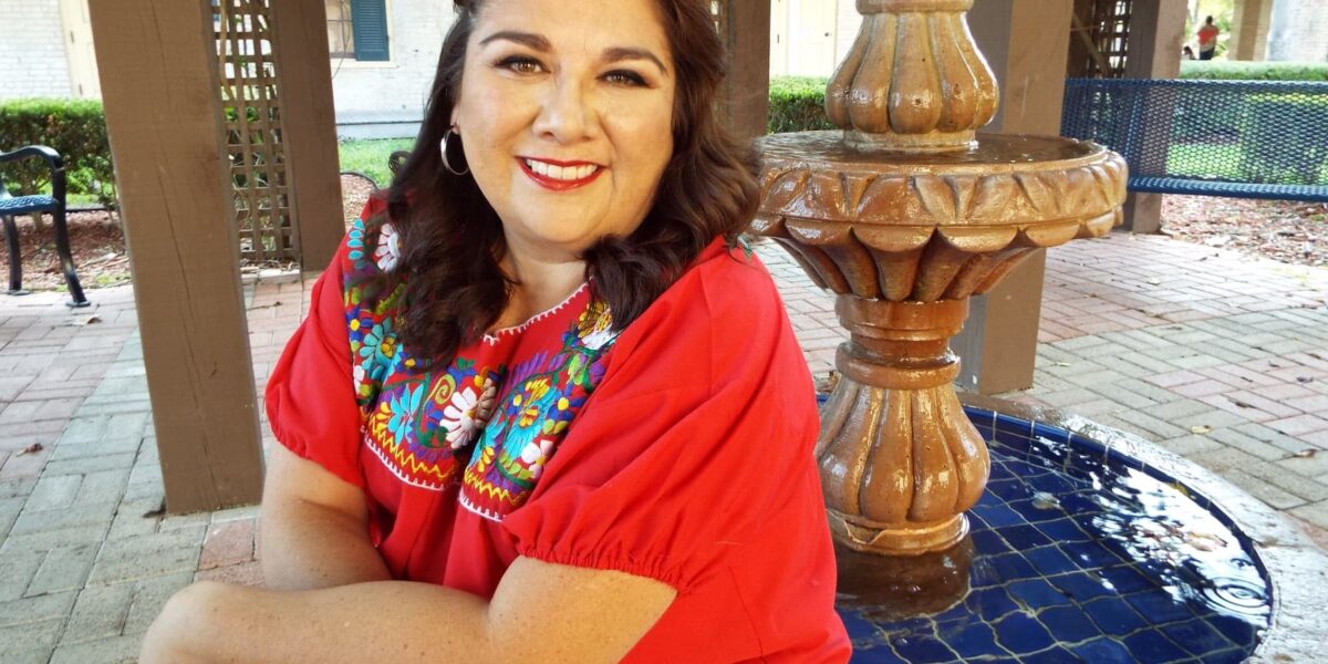 ​Ana Alicia Hinojosa sits on a fountain at the University of Texas in Brownsville where she recieved her bachelor's degree in Spanish and psychology. The fountain is a half-mile from the US-Mexican border.