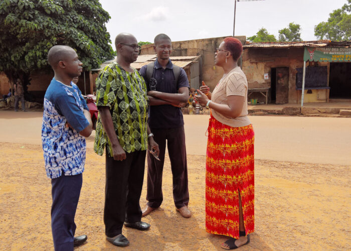 Ann Jacobs (right), from Mennonite Mission Network, speaks with Pastor Siaka Traore (in green), Pastor Joseph (in black) and Samuel (in blue), a pastor-in-training. Jacobs went on a learning-tour of African ministry locations, including this visit to Bobo