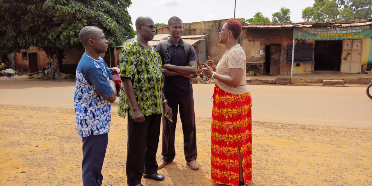 Ann Jacobs (right), from Mennonite Mission Network, speaks with Pastor Siaka Traore (in green), Pastor Joseph (in black) and Samuel (in blue), a pastor-in-training. Jacobs went on a learning-tour of African ministry locations, including this visit to Bobo
