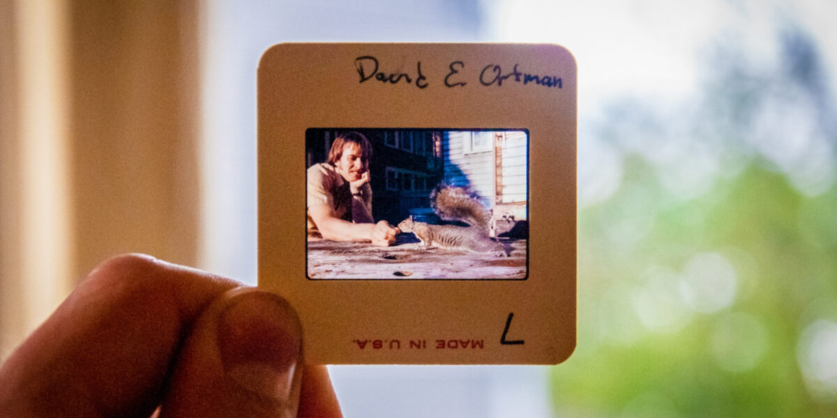 ​David Ortman feeds a squirrel outside the unit house in one of the many slides present at the MVS Seattle celebration. Ortman was an MVS Seattle participant 1975-1977 and 1978-1980. Photo by Greg Thiessen.