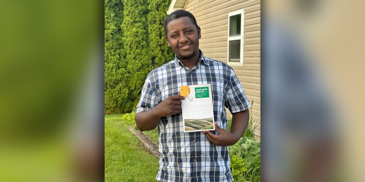 ​Henok Mekonin holds a copy of the Mission and Peace in Ethiopia issue of Anabaptist Witness. Photographer: Misgana A. Eshete