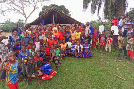 Nathan Mudiji Makumbi, standing center right with clerical collar, gathers with the Kiri Centre Mennonite Brethren congregation in the Democratic Republic of Congo after a worship service. Photographer: Glodie Kihita.
