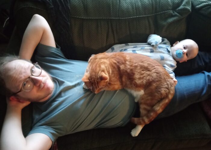 Travis Duerksen, his son, and Ollie the cat. Photo by Erica Stoltzfus.