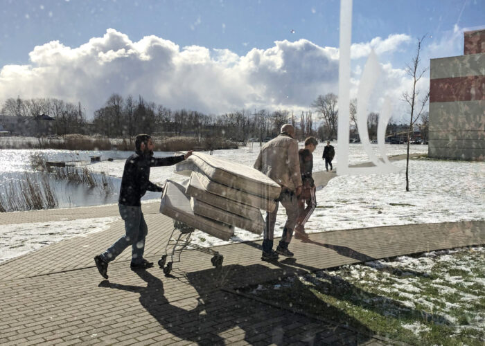 ​Students at LCC International University in Lithuania move mattresses to set up the gymnasium as a quarantine zone. Photo by Marlene Wall.