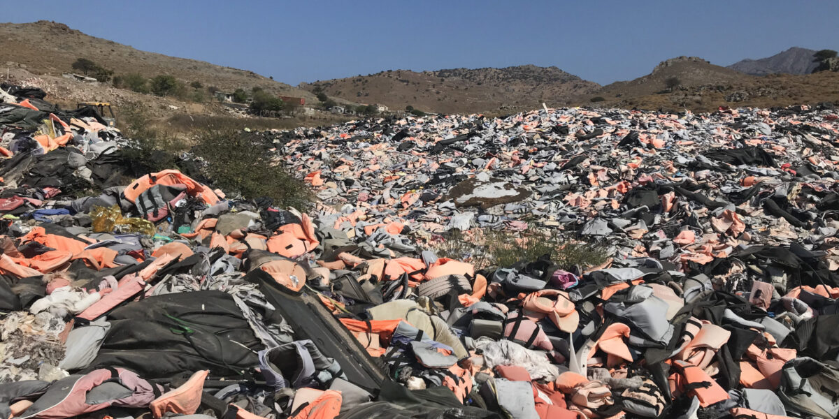 ​A doll (lower left corner) in the remnants of improvised rafts washed up on the shores of Lesbos symbolizes lives lost. Photographer: Sophie Lapp Jost