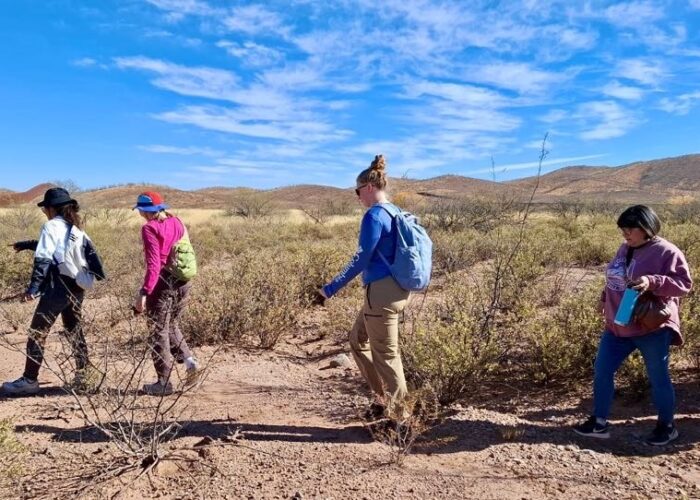 Tucson MVS members walk through the desert in Mexico near the U.S. border wall. From left are Zing Bawi Ken, Hannah Lehman, Schyler Entz and Lisa Showalter (local program coordinator for the unit). Photo provided.