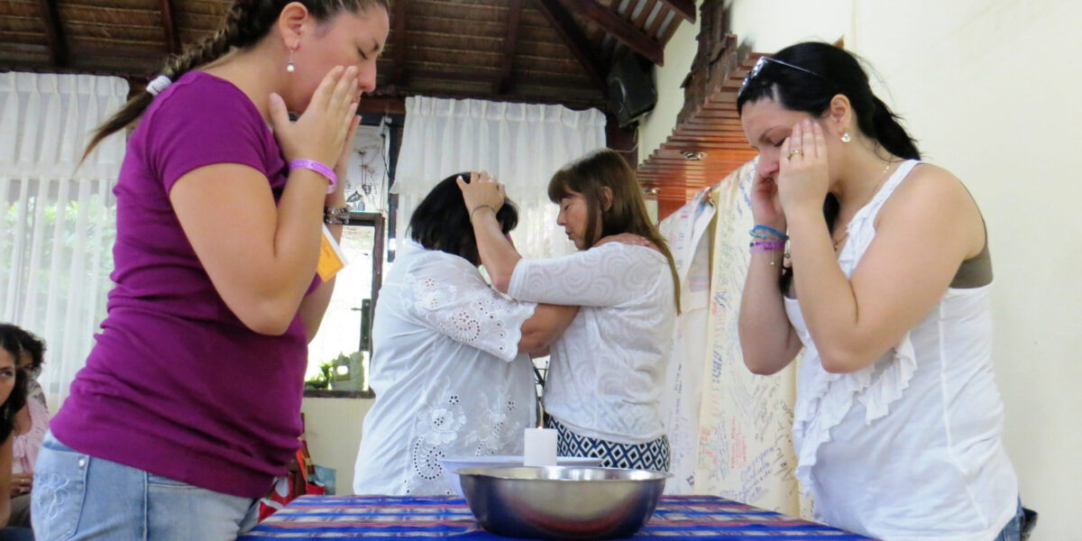 ​Marcia Soto and Alejandra Molina (foreground) and Estela Armoa and Aurora Rinaldi give and receive prayers and blessings at a Sister Care gathering in Bolivia. Photo provided. Click image for high resolution version.