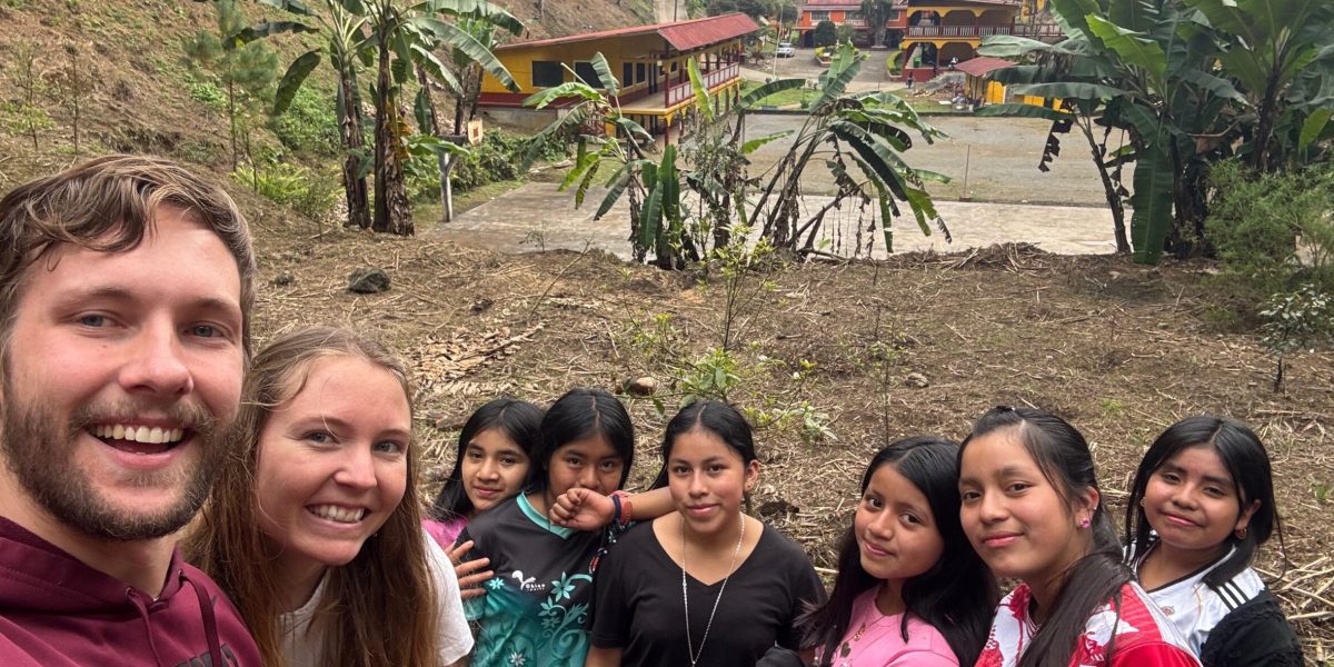 The segundo basico students pose for a photo in the avocado grove on the Q’eqchi’ Bezaleel Mennonite Educational Center campus.