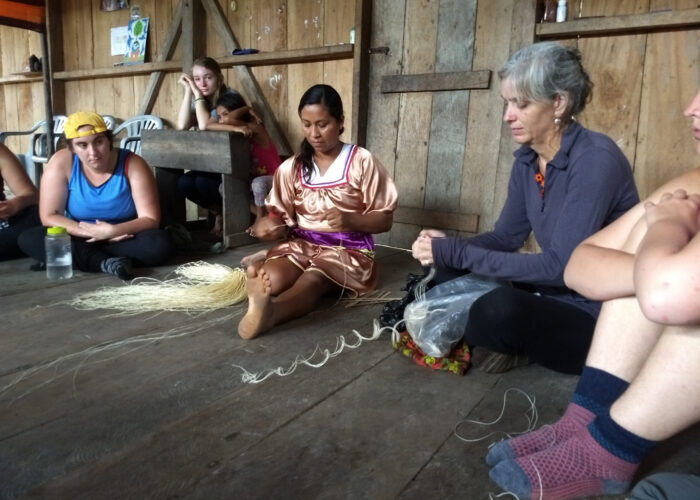 ​Gladys Mendua demonstrates how to weave a bag out of palm fibers to a Goshen College class. Photo provided.